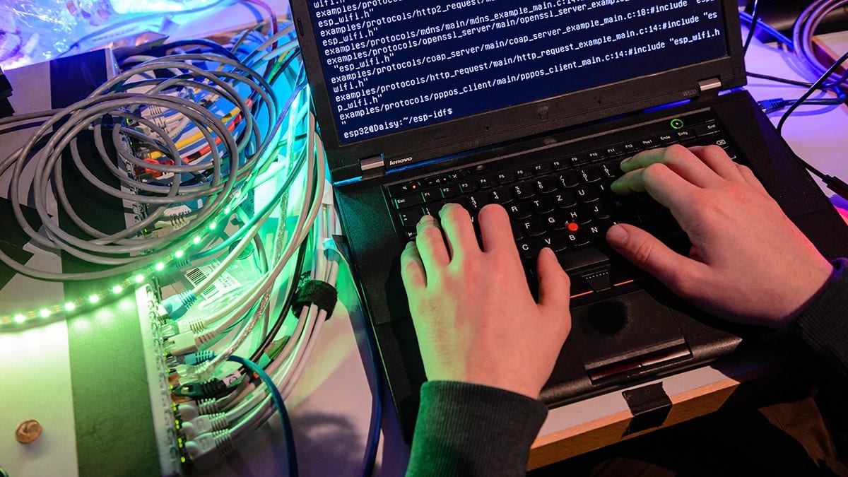 Hacker using a laptop in a dimly lit environment