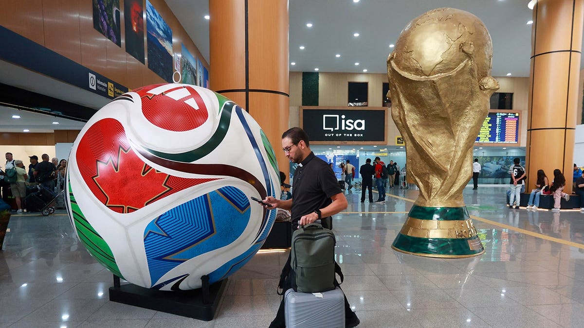 Figures of FIFA World Cup trophy and official match ball displayed at airport in Mexico City