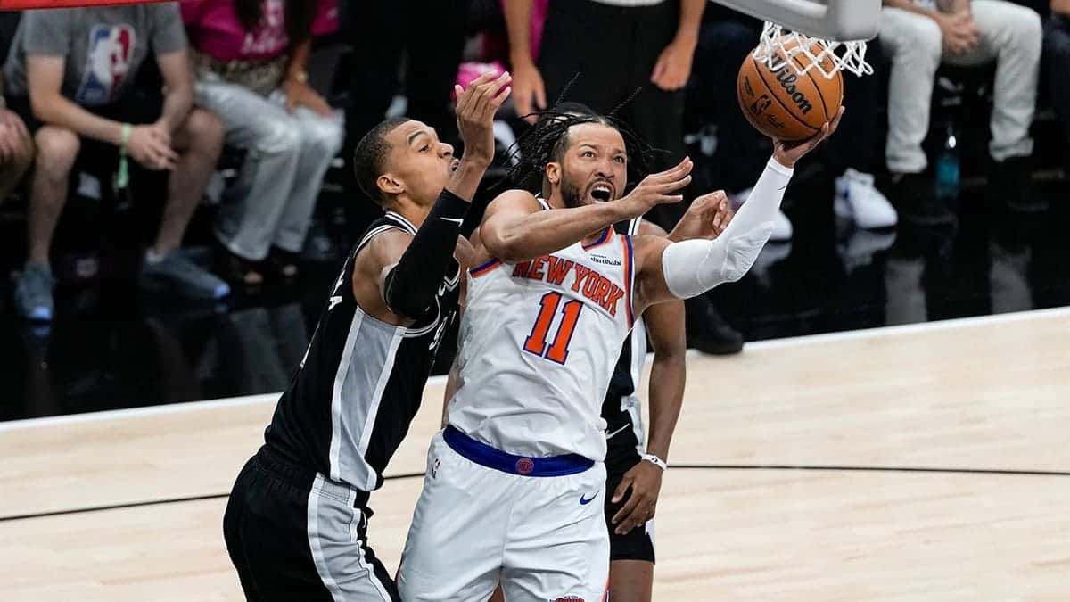 New York Knicks guard Jalen Brunson drives past San Antonio Spurs forward Victor Wembanyama during NBA Finals game.