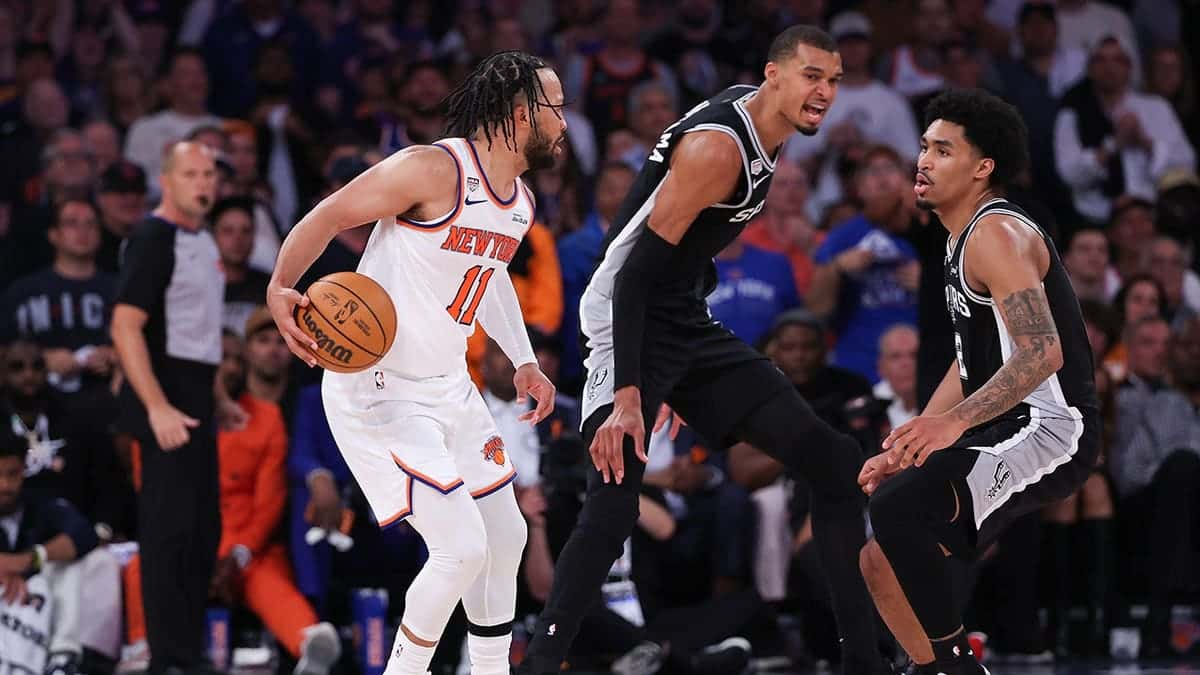 Jalen Brunson dribbling basketball against Dylan Harper and Victor Wembanyama at Madison Square Garden