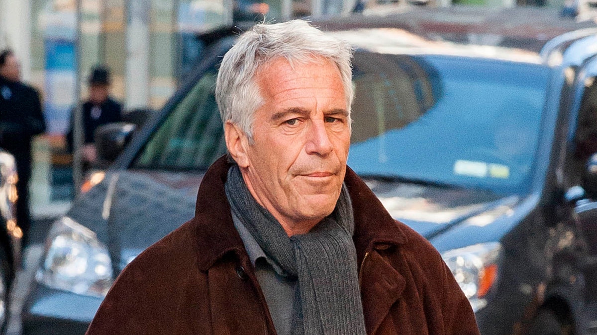 Jeffrey Epstein walking outdoors in New York City wearing a suit and tie.