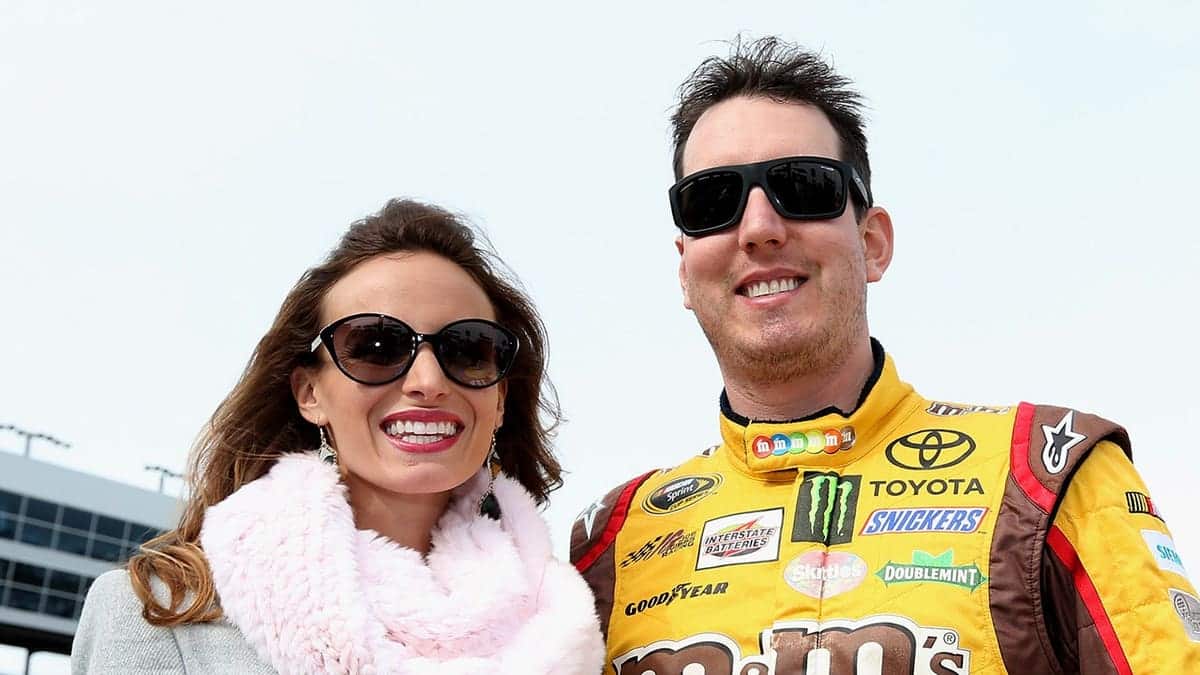 Kyle Busch and his wife Samantha Busch standing on the grid at Texas Motor Speedway.