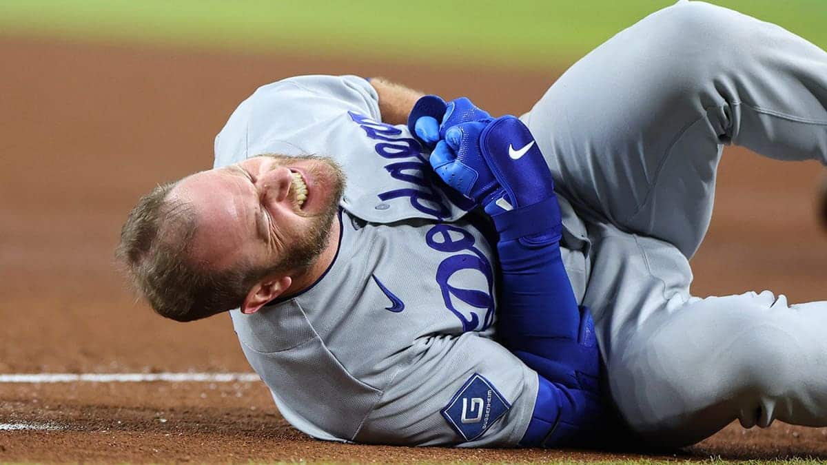 Los Angeles Dodgers third baseman Max Muncy reacting to injury at first base during game