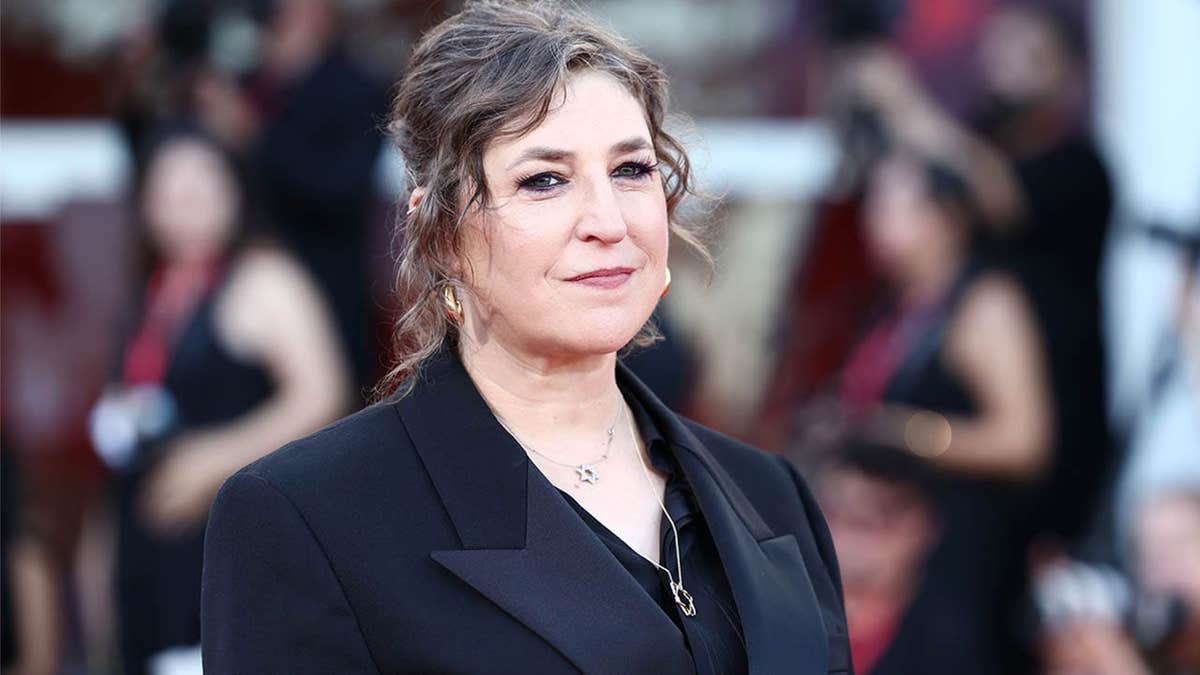 Mayim Bialik standing on the red carpet at the Venice International Film Festival.