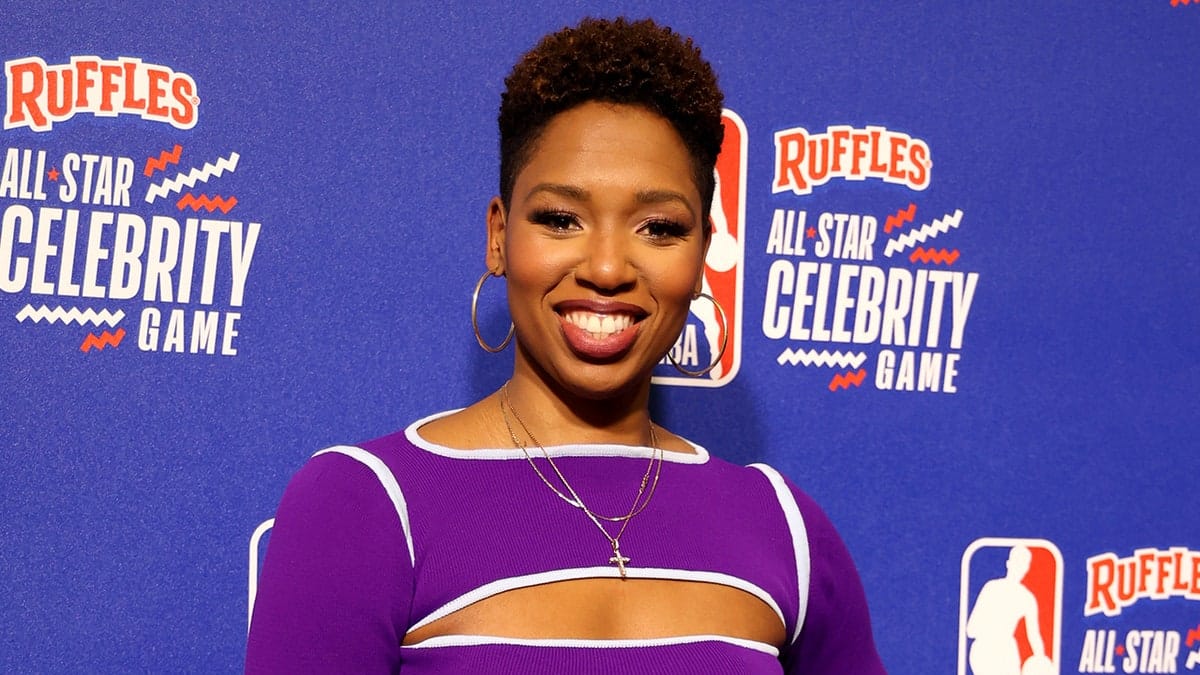 ESPN analyst Monica McNutt standing on the red carpet at Lucas Oil Stadium in Indianapolis