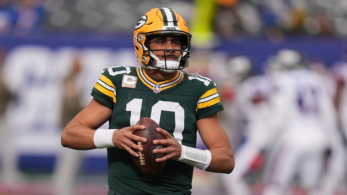 Green Bay Packers quarterback Jordan Love warming up on the field.