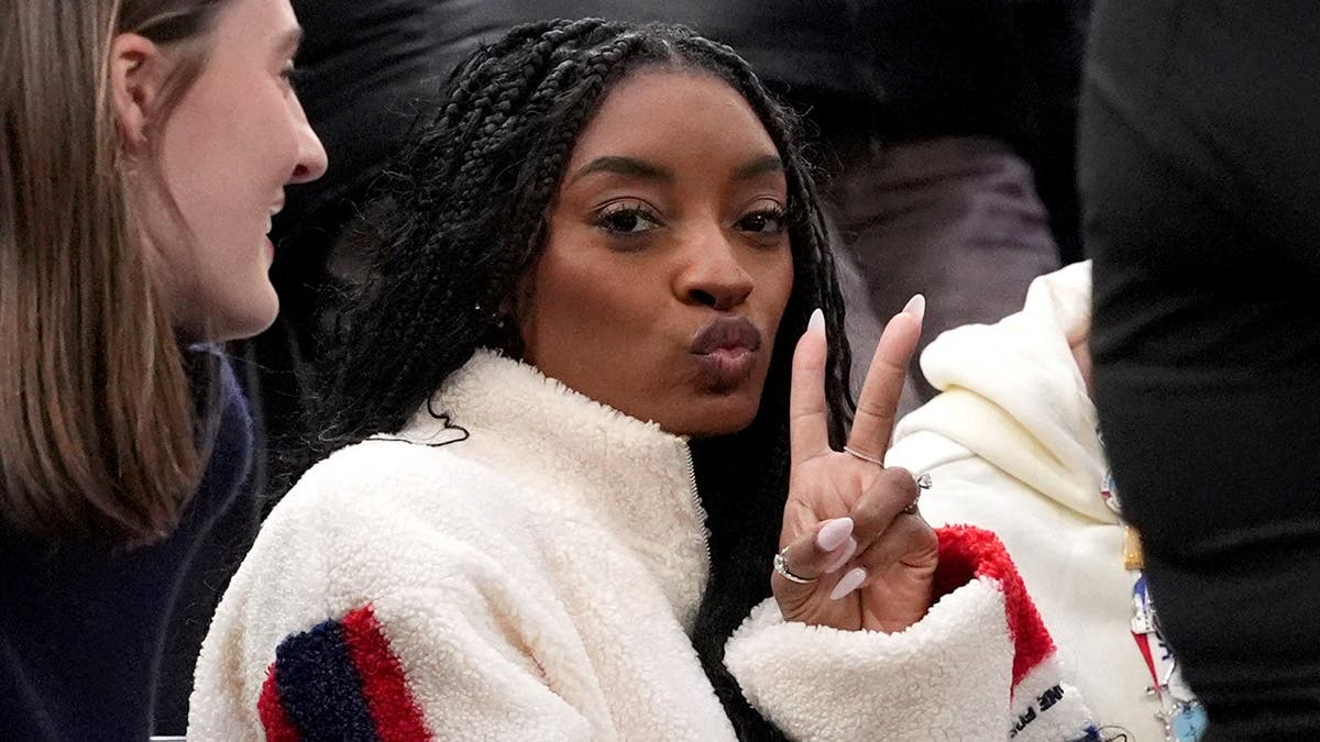 Simone Biles seated in the stands at Milano Santagiulia Ice Hockey Arena.