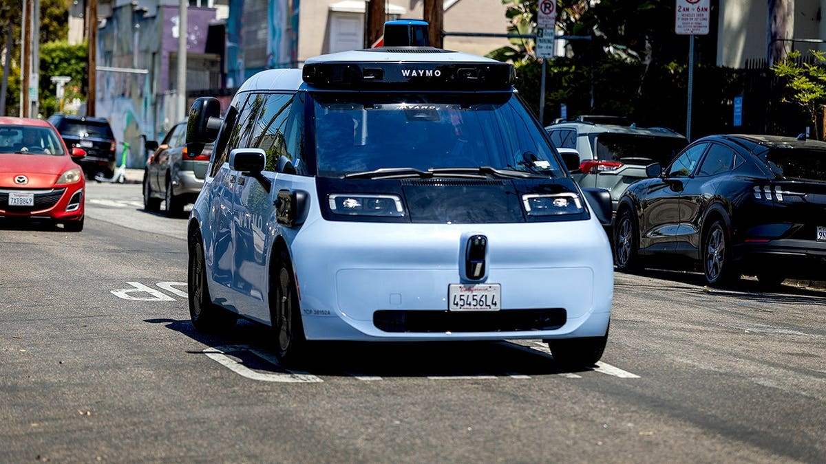 A Waymo Ojai robotaxi drives down the road.