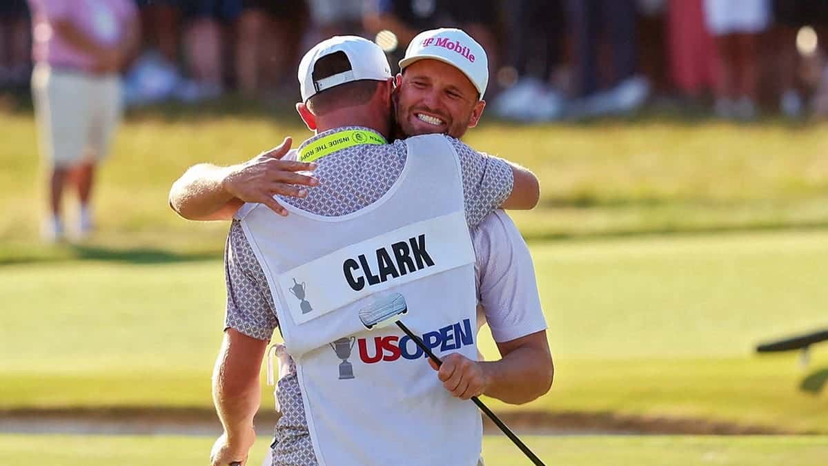Wyndham Clark celebrating with caddie David Pelekoudas at Shinnecock Hills Golf Club