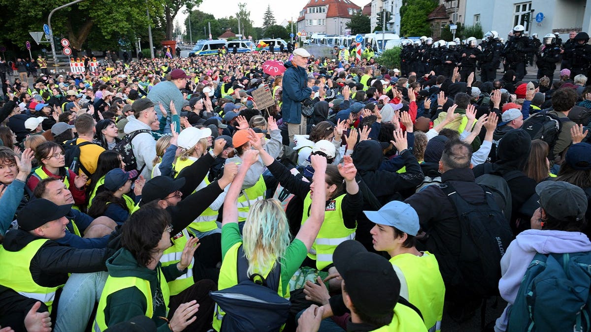 German police in the background watch as demonstrators have gathered for a sit-in