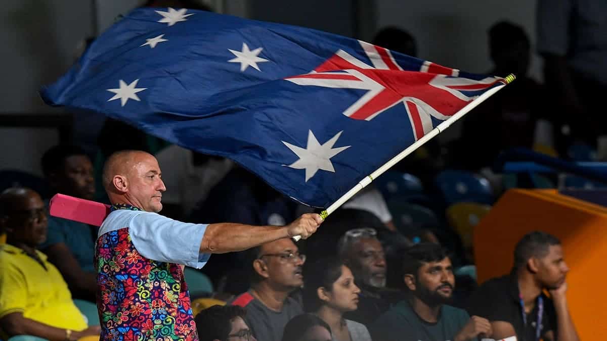 Supporter waves an Australia flag at a cricket match.