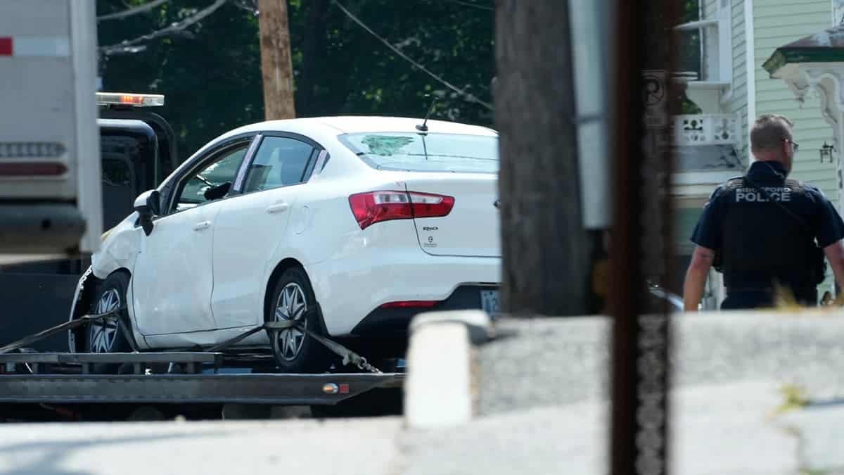 A white car on a flatbed truck