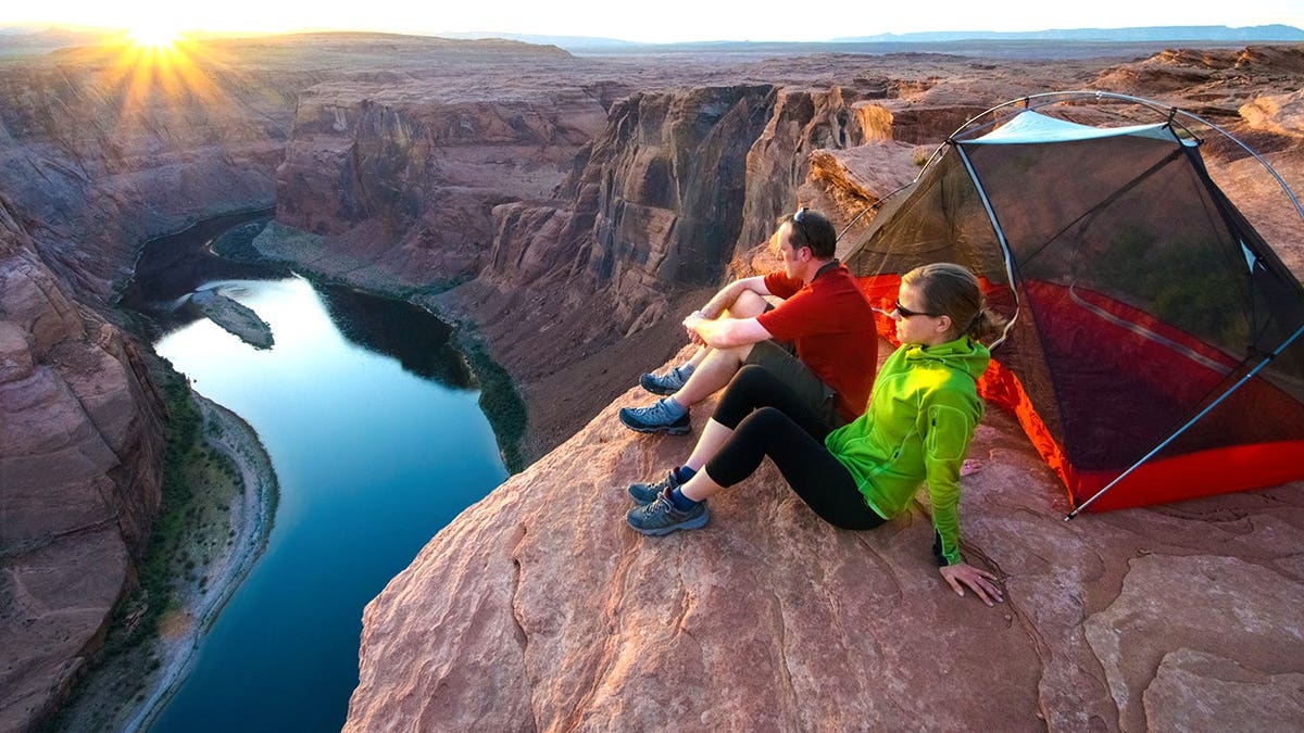 Campers looking at sunset from cliff