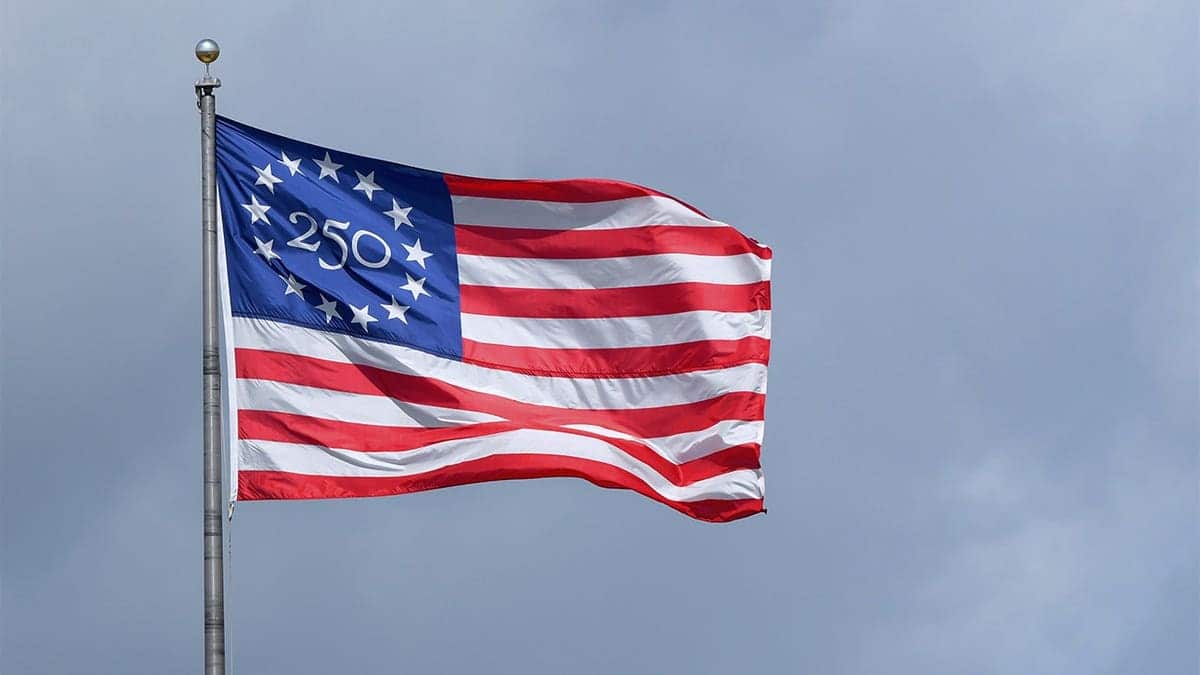 A detailed view of the special commemorative 250th anniversary American flag flying at a baseball stadium.