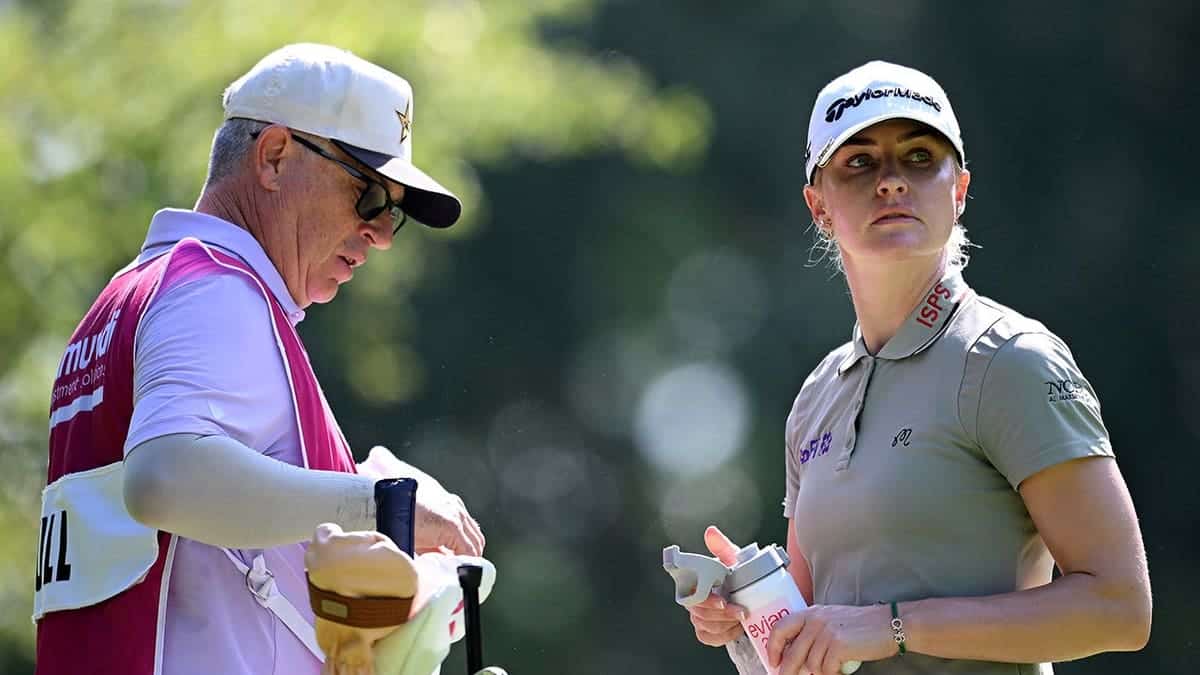Charley Hull of England talks with her caddie Adam Woodward on the fourth hole.