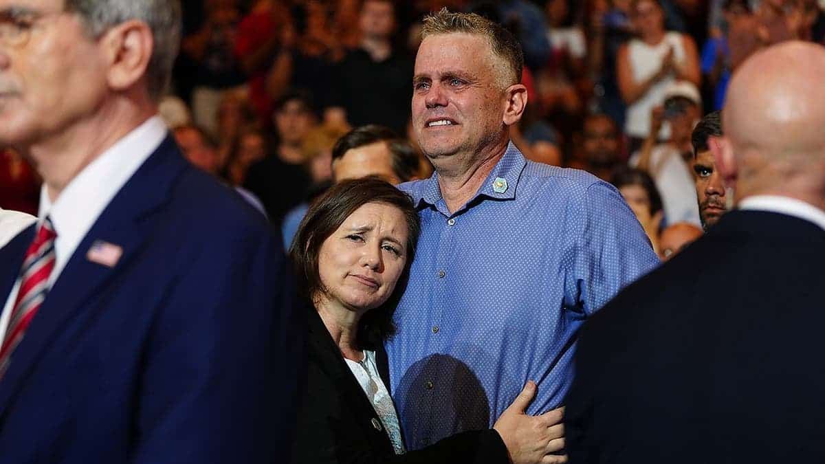 Shari and Stephen Feehan listen as President Donald Trump honors their son at Wheeler High School in Marietta, Georgia