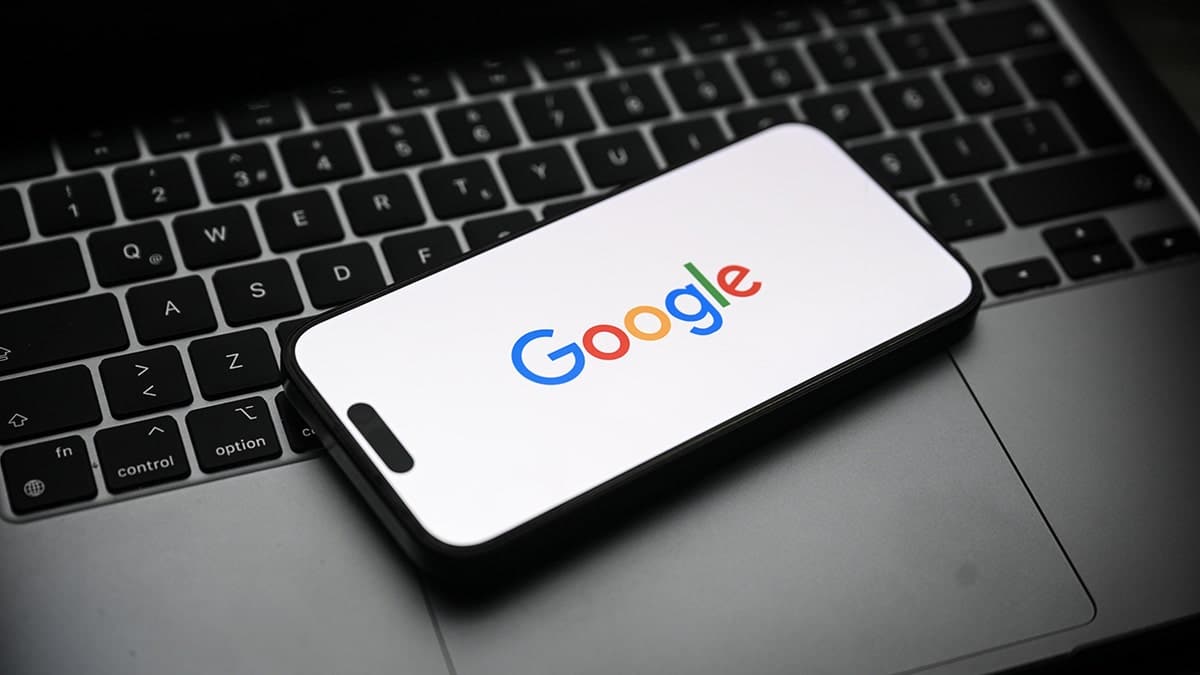 A smartphone resting on a laptop.
