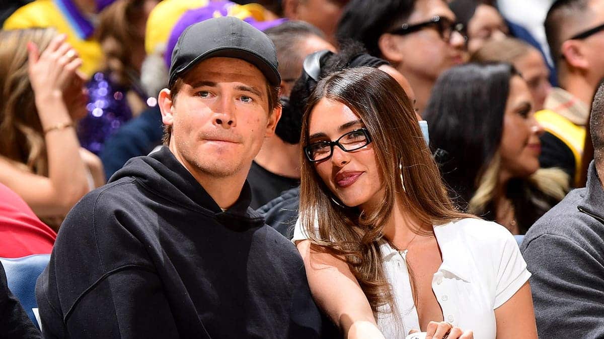 Justin Herbert and Madison Beer sit at a basketball game in Los Angeles.