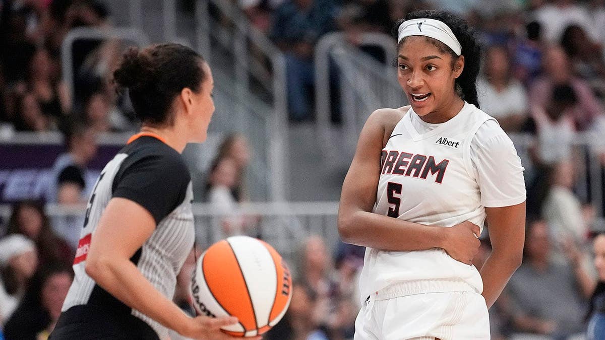 Angel Reese talks with game official Tiara Cruse during play at Coca-Cola Coliseum.