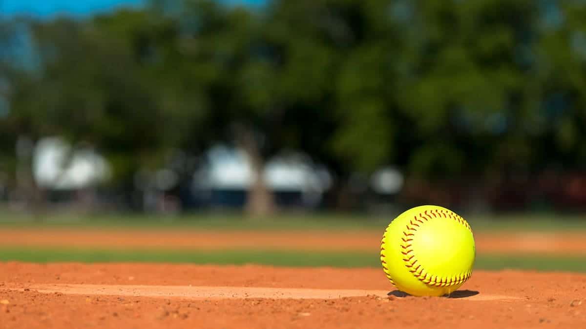 Softball sits on a baseball diamond.