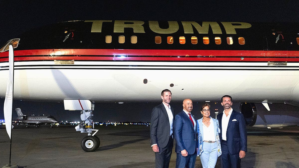 Donald Trump Jr., Eric Trump and others at the Donald J. Trump International Airport with Trump Force One in background