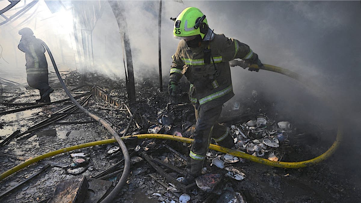 Ukrainian firefighters extinguish a fire at a market in Kyiv following a Russian missile strike.