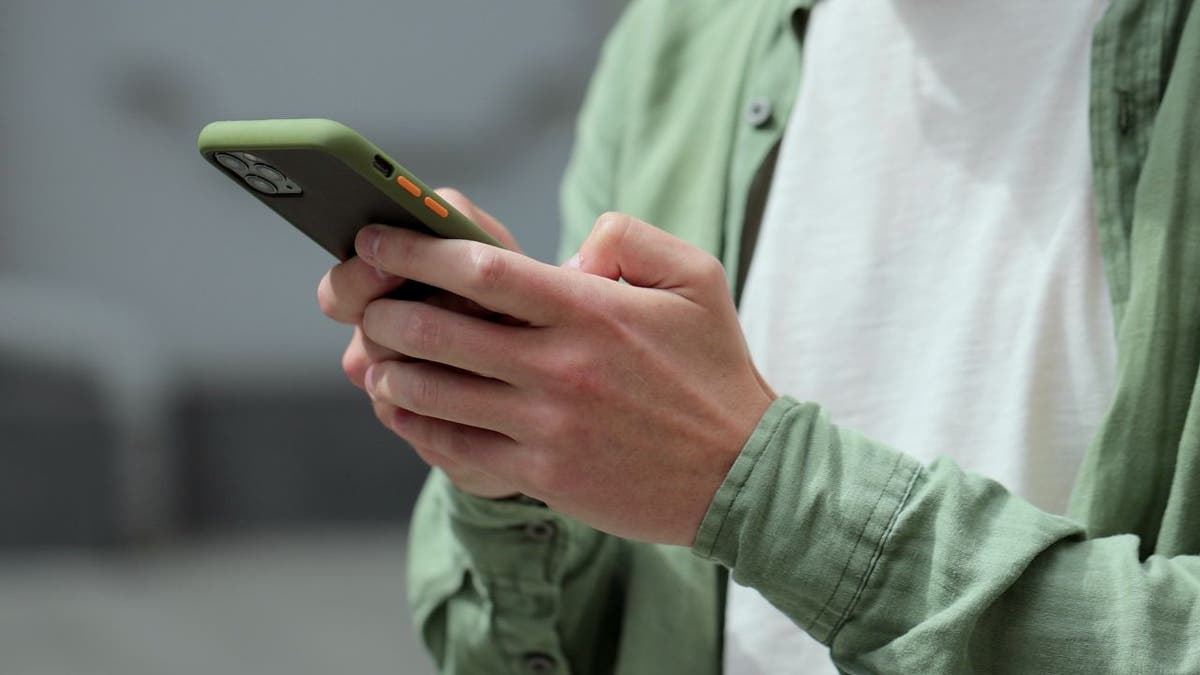 A man texting on his iPhone.