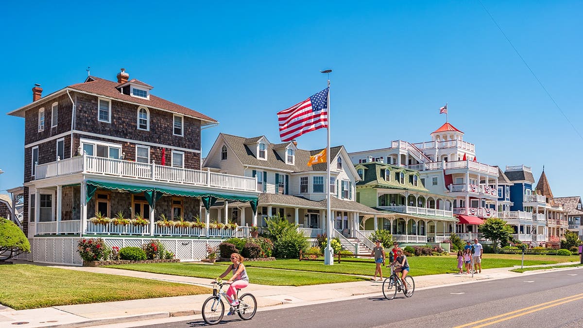 Victorian homes with bicycle riders in front of it in Cape May, New Jersey.