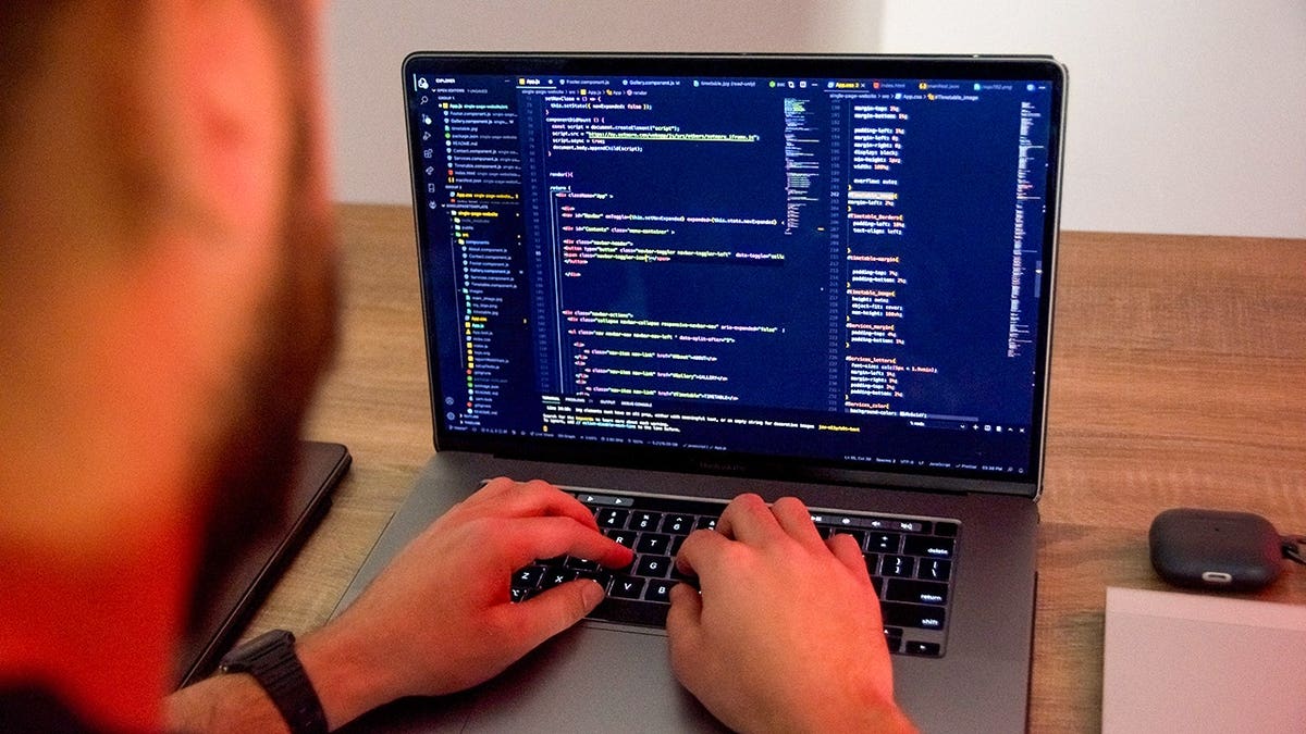 Man coding on his laptop.