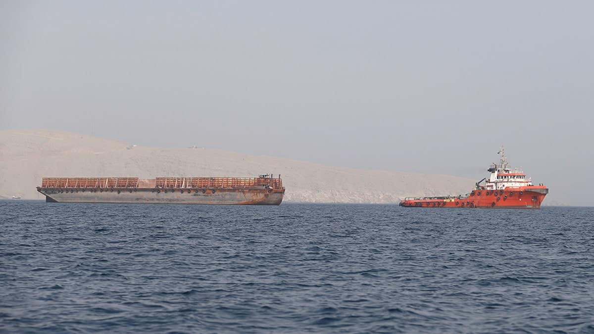 FILE PHOTO: A tug boat moves cargo towards the Strait of Hormuz, in Musandam province, Oman, July 20, 2018. Picture taken on July 20, 2018. REUTERS/Hamad I Mohammed/File Photo - RC1549765850