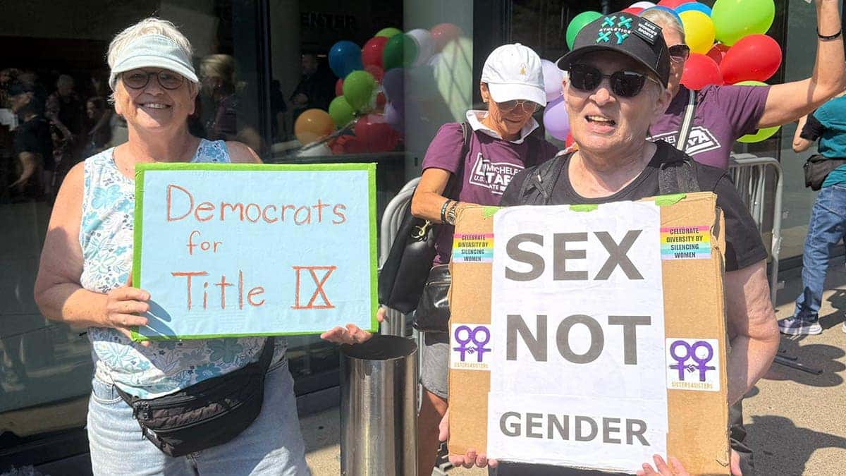 women's sports supporters hold signs at Minnesota rally