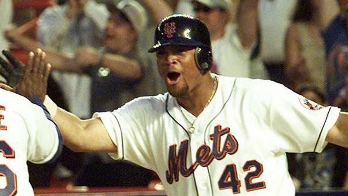 Brian McRae crosses home plate as Butch Huskey congratulates him at Shea Stadium.