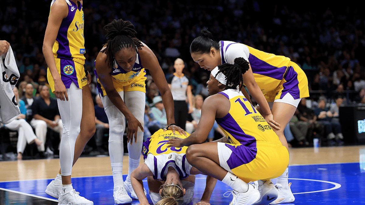 Cameron Brink is attended to by Los Angeles Sparks teammates after a collision during a game at Barclays Center.