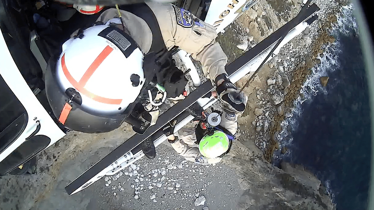 CHP helicopter rescue technician prepares for a technical hoist above the rocky Big Sur coast