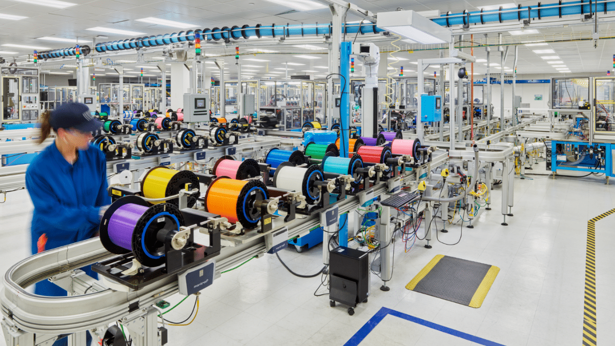 A Corning employee handles optical fiber as part of the manufacturing process that supports broadband and telecommunications infrastructure.