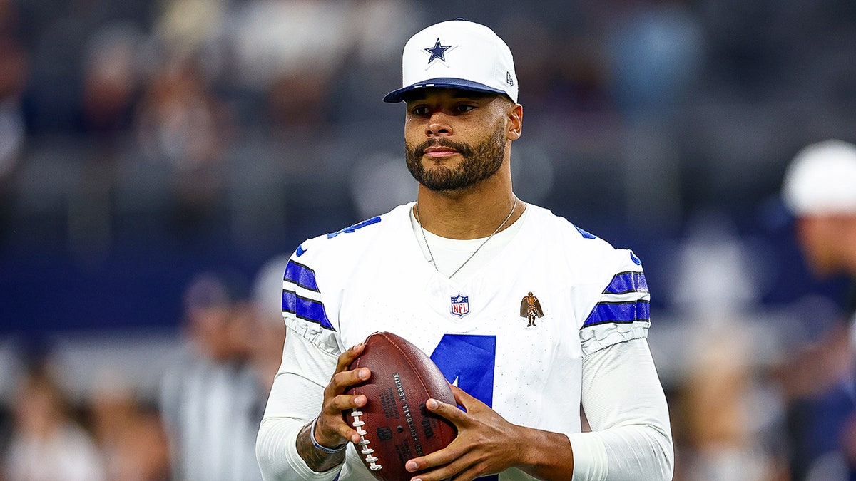 Dak Prescott looks on field before game