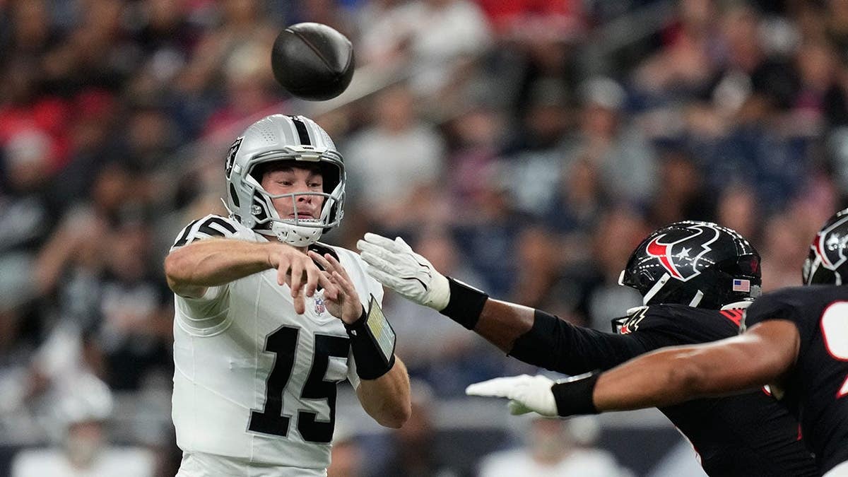 Fernando Mendoza, Las Vegas Raiders quarterback, throws under pressure during an NFL preseason game.
