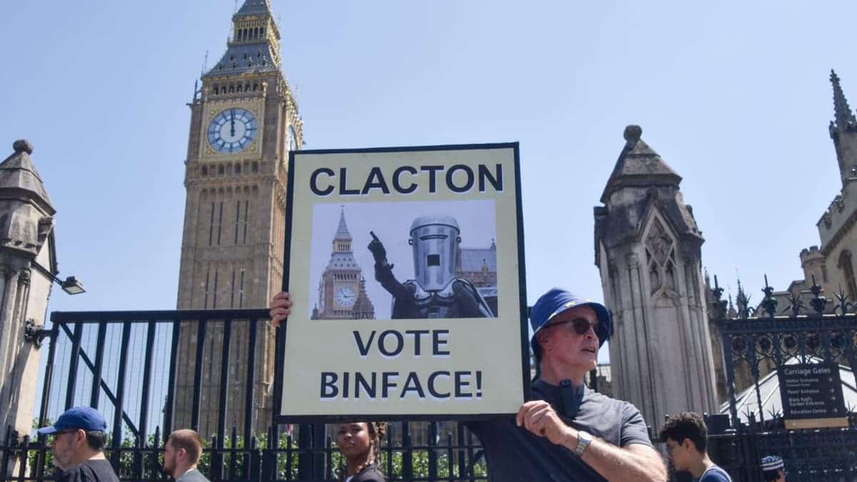 An activist holds a placard urging Clacton to vote for the