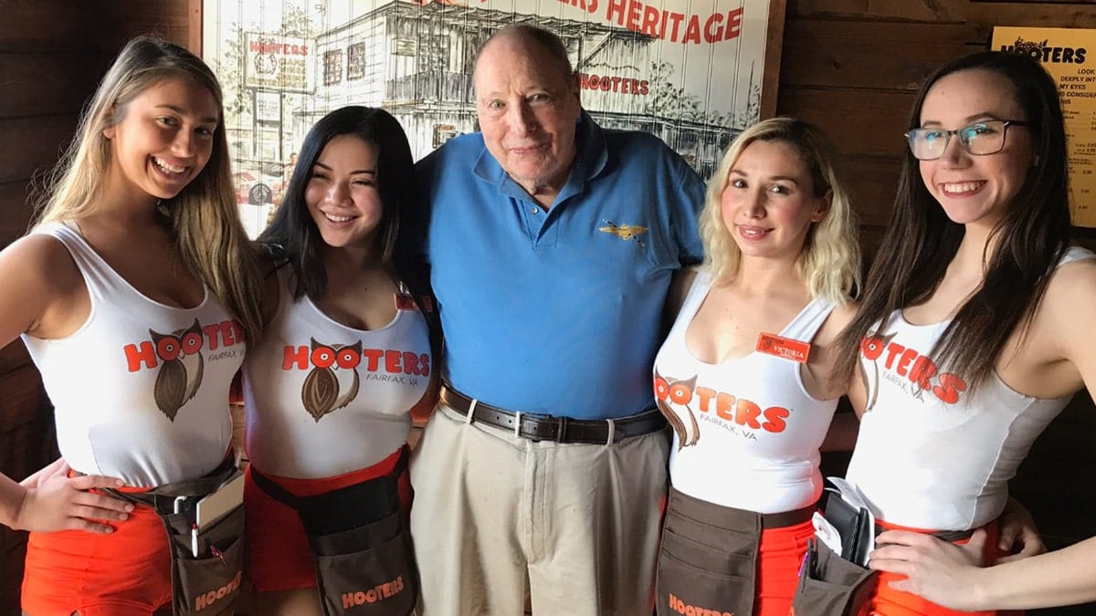 A Navy veteran poses with four Hooters waitresses in Fairfax, Virginia.