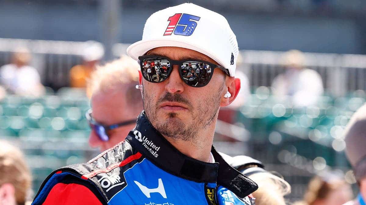 Graham Rahal stands on pit lane with his Honda race car at Indianapolis Motor Speedway.