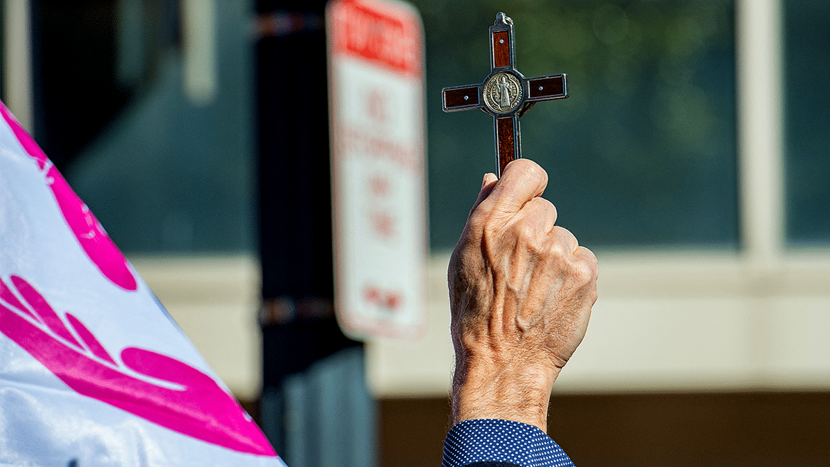 Man holding up a cross