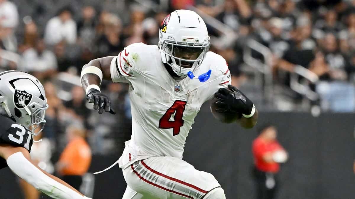 Jeremiyah Love runs past Treydan Stukes during preseason NFL game.