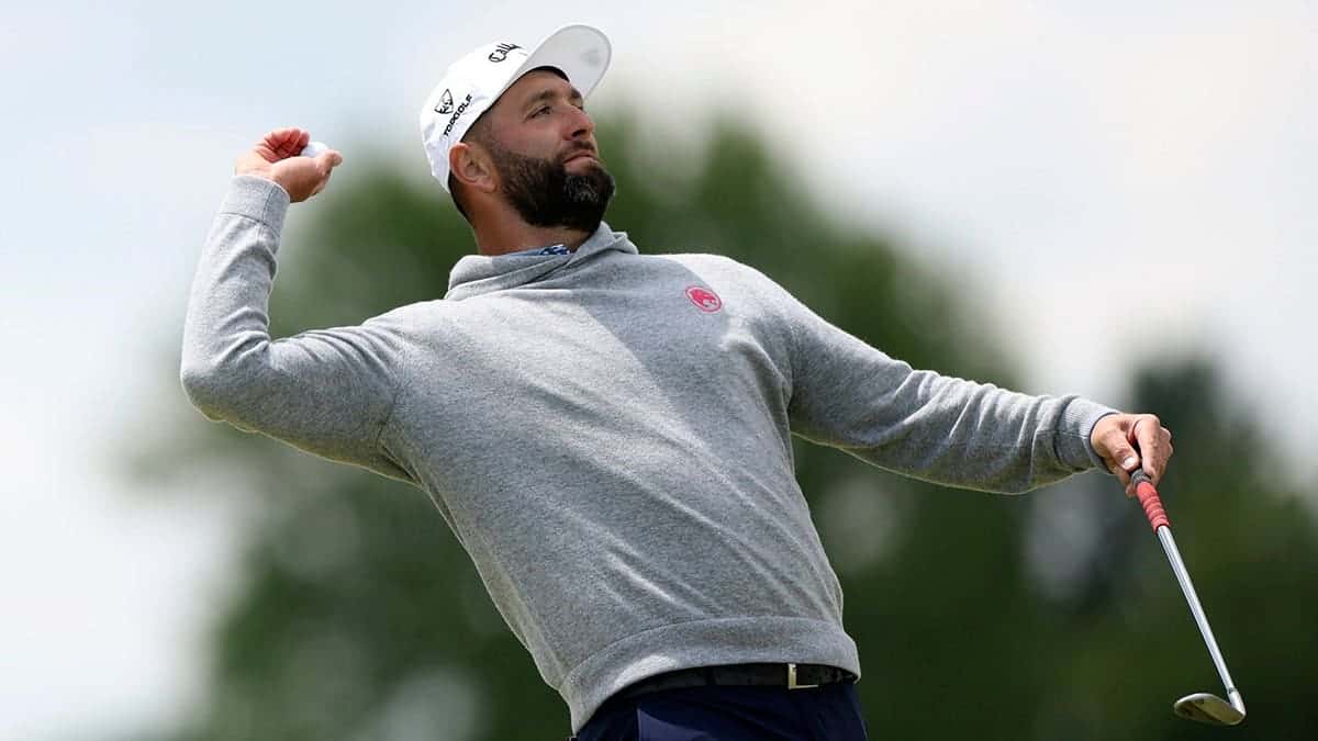Jon Rahm tossing golf ball toward crowd on second green at Aronimink Golf Club