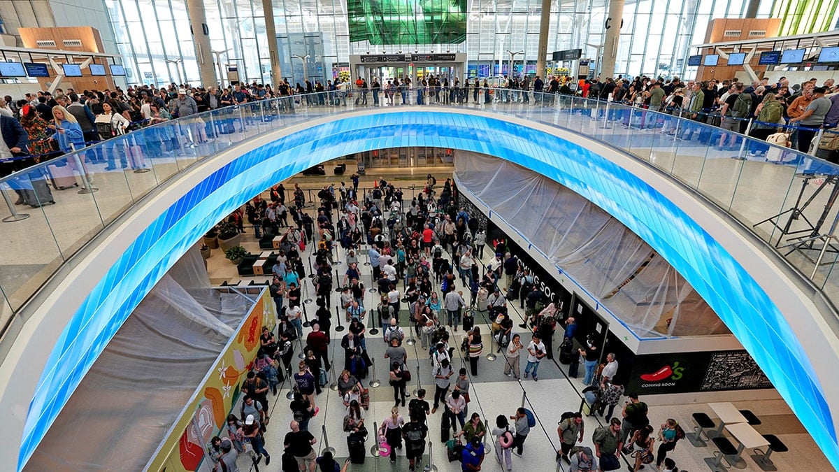 Travelers wait in long security lines at an airport