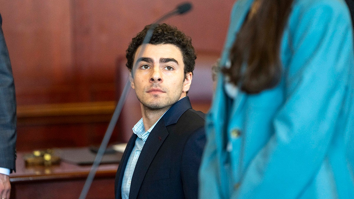 Luigi Mangione appearing at an evidence suppression hearing in a courtroom.