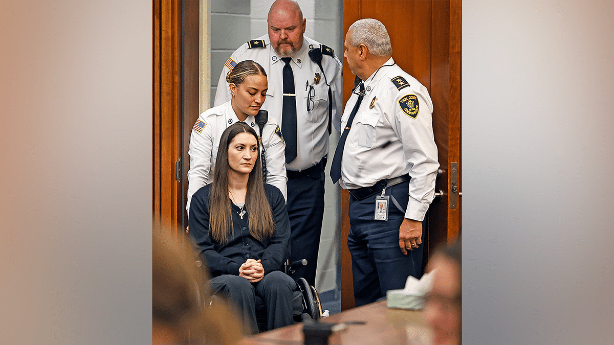 Massachusetts mother accused of killing her three children sits in a wheelchair during court appearance