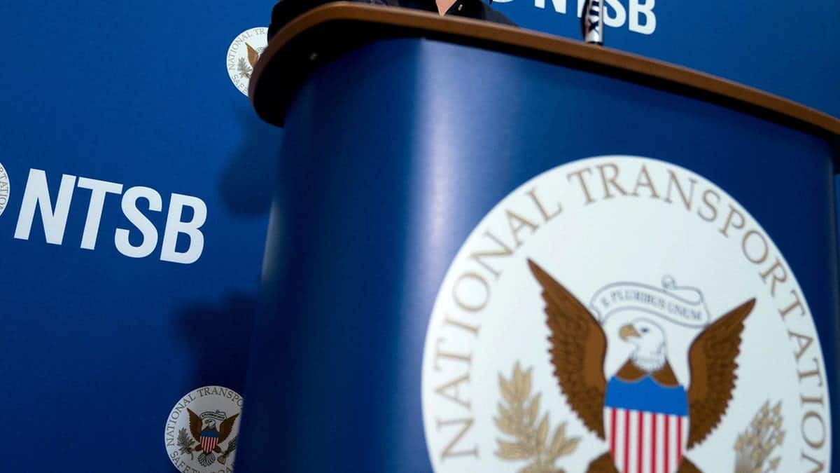 National Transportation Safety Board logo and signage displayed at a news conference.