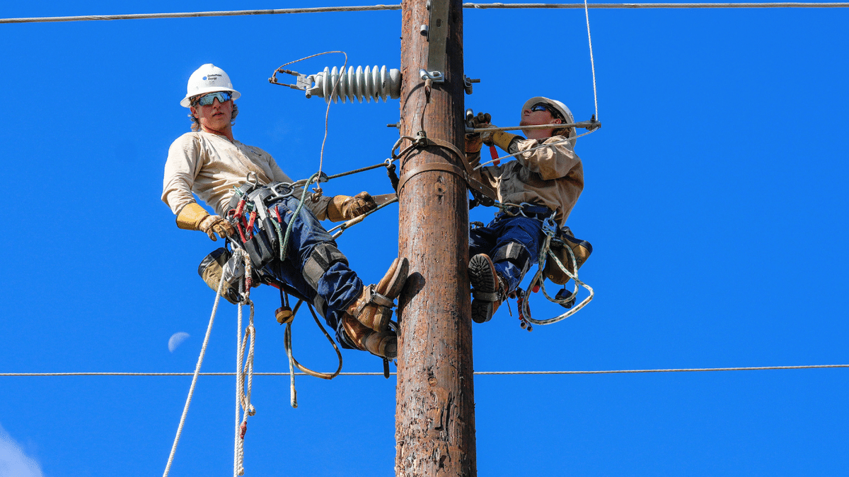 Men are seen working on a power line in Houston, Texas.