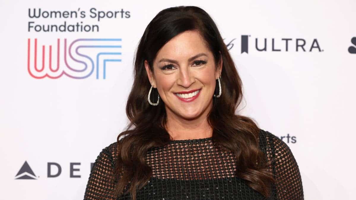 Sarah Spain smiling at a Women’s Sports Foundation event in front of a WSF backdrop.