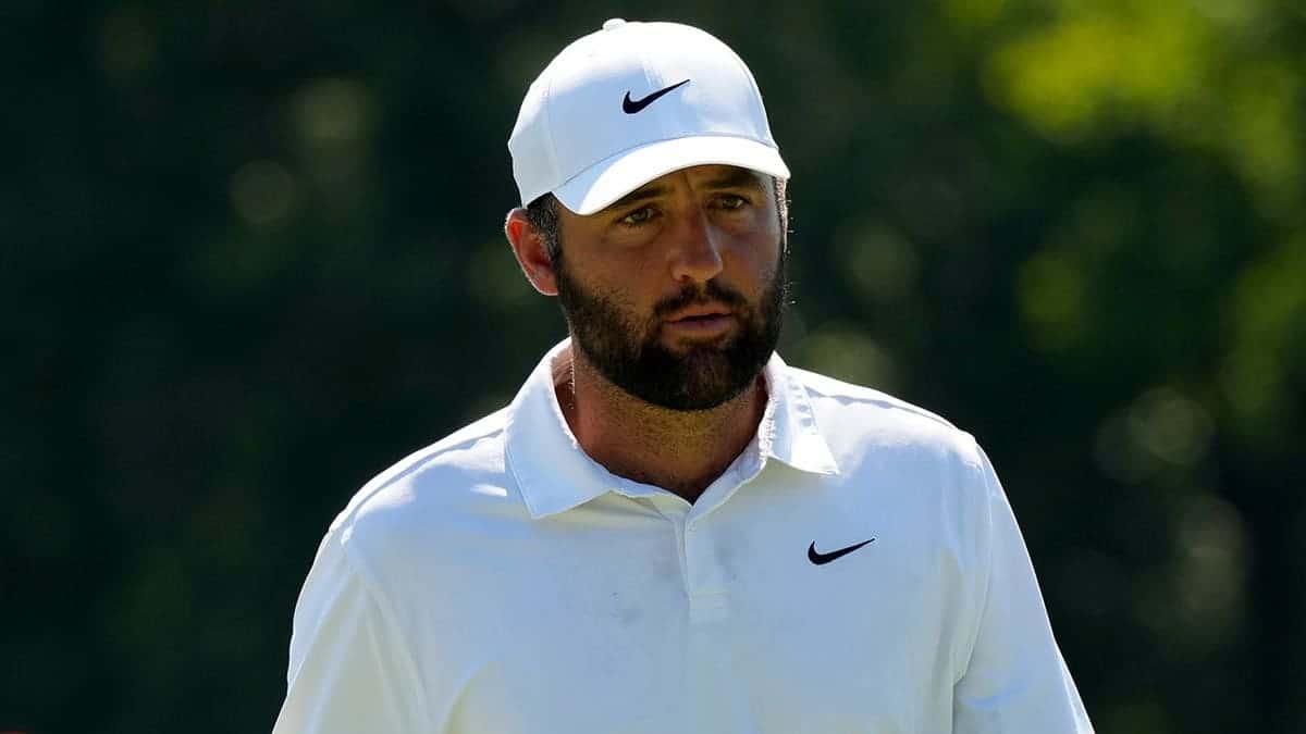 Scottie Scheffler walks off the 18th green during a golf tournament.